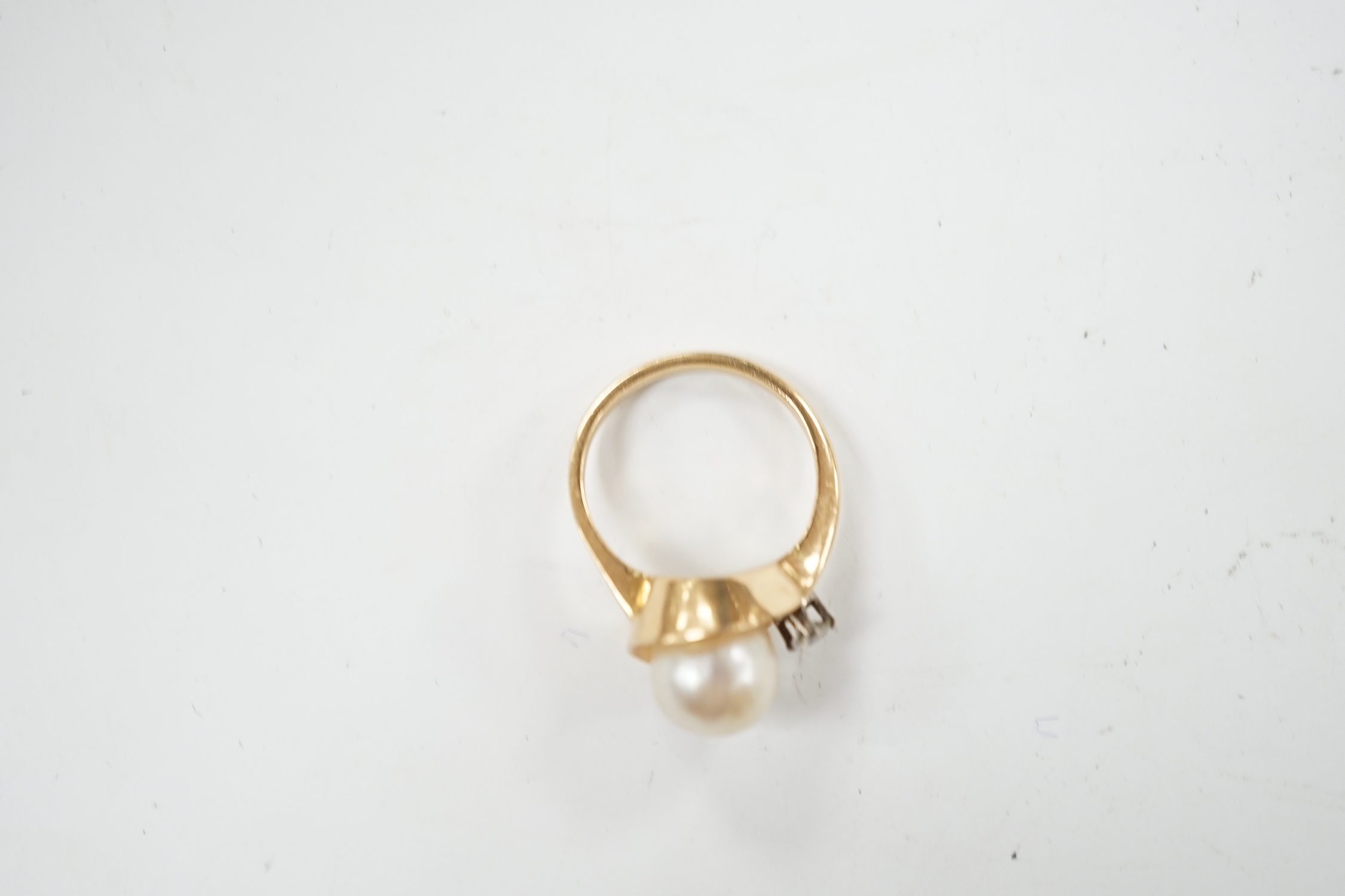 A yellow metal , single stone cultured pearl and single stone diamond set ring, size J, gross weight 4.8 grams.